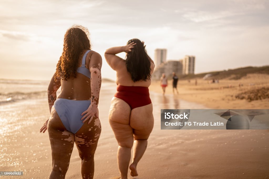 Rear view of friends walking in the beach Beach Stock Photo