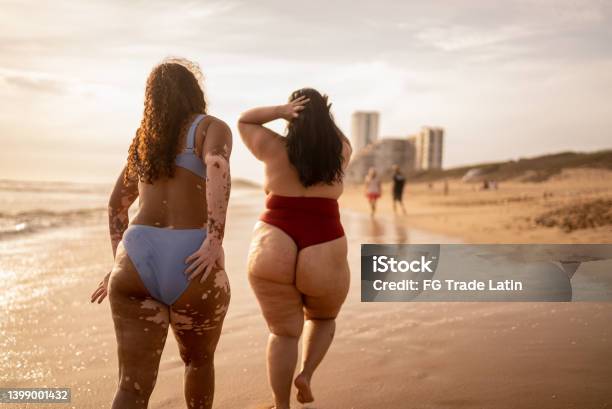 Rear View Of Friends Walking In The Beach Stock Photo - Download Image Now - Beach, Swimwear, Overweight