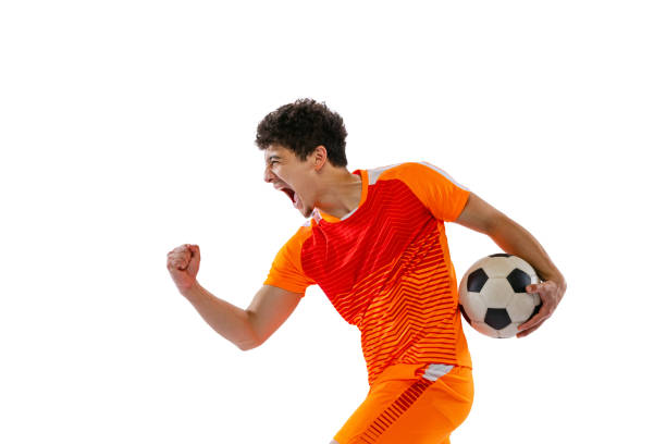 Winner emotions. Portrait of young man, football, soccer player posing with ball isolated on white studio background. Concept of sport, match stock photo