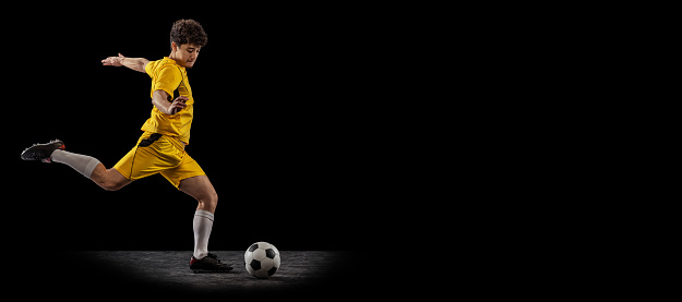 Excited running, aspirated. Football or soccer player on full stadium and flashlights background. Cropped close up with copyspace. Concept of sport, competition, winning, action and motion.
