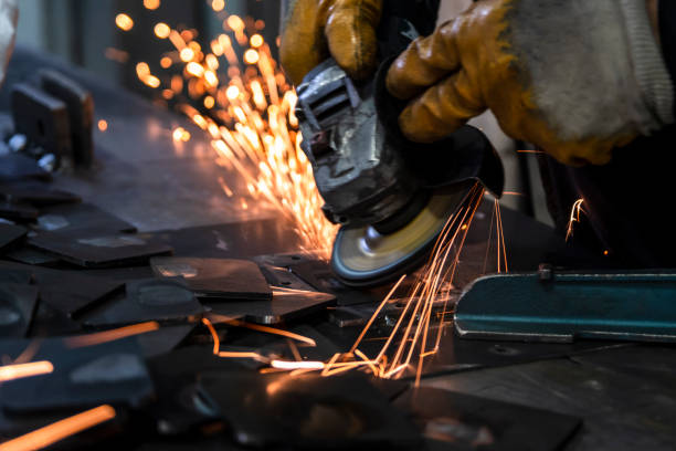 Sparks from the grinding wheel. Grinding metal plates with electric wheel in factory. Sparks from the grinding wheel. Selective focus grinding machine and metal plates. Motion blur sparks grinding metal power work tool stock pictures, royalty-free photos & images