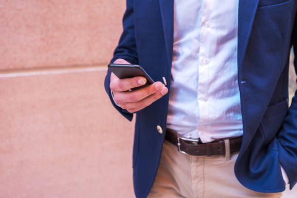 istock Smart casual clothing young businessman using smart phone at city 1399005663
