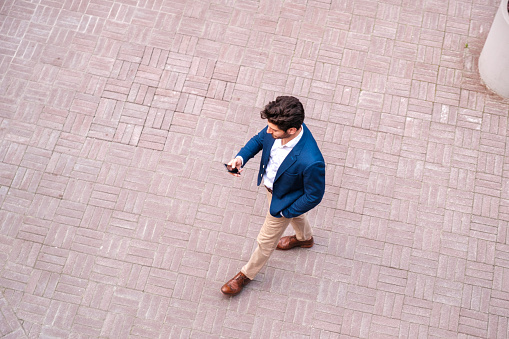 Smart casual clothing young businessman using smart phone at city