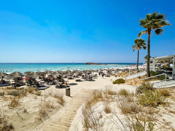 People at Nissi Bay beach, Aiya Napa island in background, Cyprus.