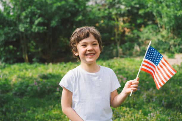 garçon patriote tenant le drapeau américain - usa child flag the americas photos et images de collection