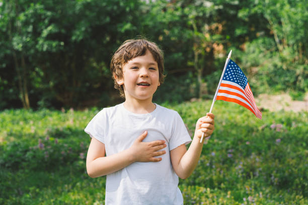istock Patriotic boy holding American flag 1399009848