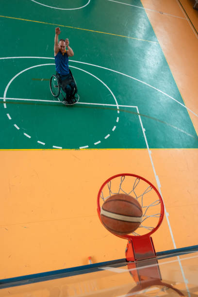 zdjęcie z góry osoby niepełnosprawnej grającej w koszykówkę halową - playing an instrument vertical blurred motion outdoors zdjęcia i obrazy z banku zdjęć
