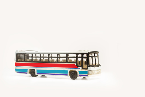 A toy city bus on a gray background with copy space