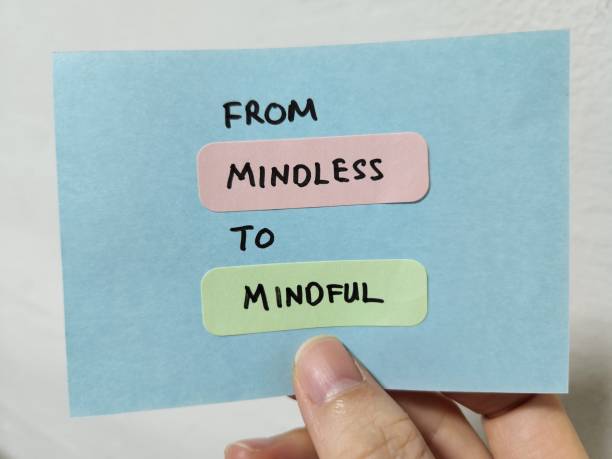 hand holding a note showing the words from mindless to mindful - spiritual practices imagens e fotografias de stock