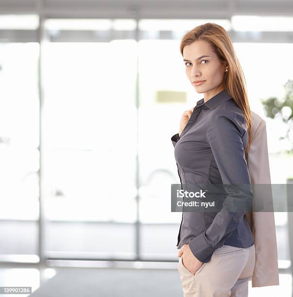 Giovane Donna In Carriera Lasciando Ufficio - Fotografie stock e altre immagini di Sorridere in modo compiaciuto - Sorridere in modo compiaciuto, Ufficio, 25-29 anni