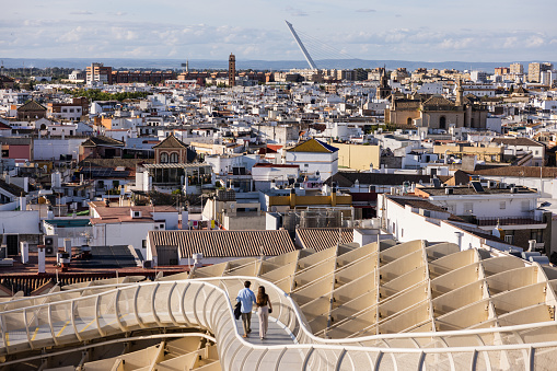 Seville, Spain, April 9, 2022: On the Metropol Parasol during a sunny and warm spring day on April 9, 2022 in Seville, Spain. People enjoy the rooftop view of the Metropol Parasol architecture, with a broad view of the city skyline.