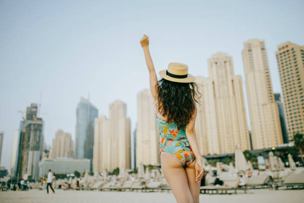 istock Young woman walks towards beautiful beach 1399015231