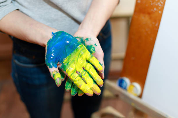 istock hands in paint yellow blue close-up. Ukrainian War 1399017651