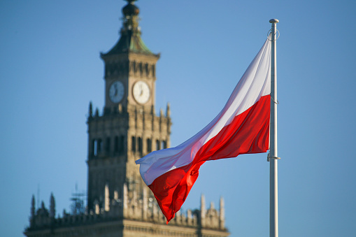 Flag of Poland and Palace of Culture and Science in Warsaw, Poland.
