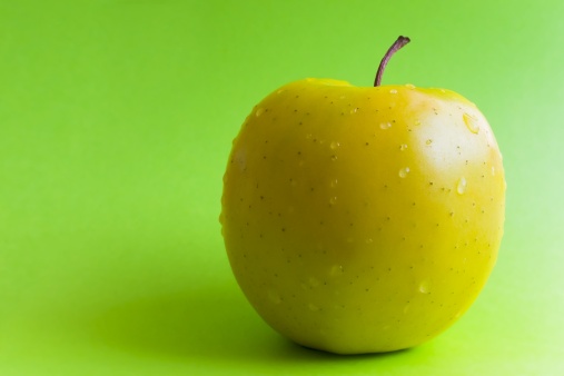 Yellow apple on a green background