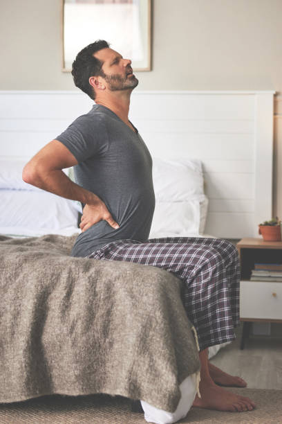istock A man feeling back pain in bed at home. A mature guy looking unhappy, stressed and feeling sick in his bedroom during the morning 1399020090