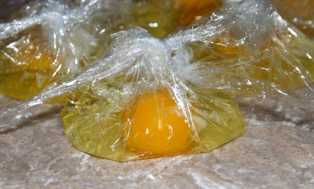 Eggs in plastic bags for making eggs benedict stock photo