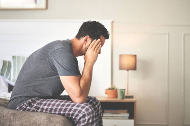 istock A man feeling stressed and suffering from a headache in bed at home. A mature guy looking unhappy, feeling sick in his bedroom during the morning 1399020407