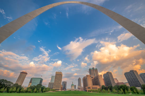 The St. Louis Arch towers above the Mississippi River landing on a cloudy day in the summer month of August.