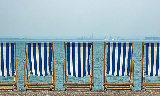 Five striped beach chairs overlooking the sea