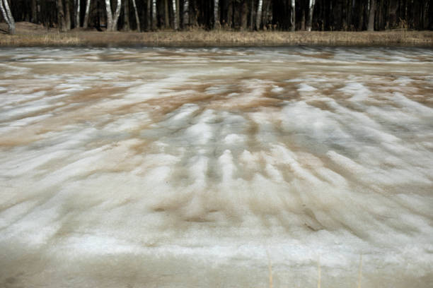 Ice is melting on lake. Spring Pond. Melted snow in forest. View of reservoir.