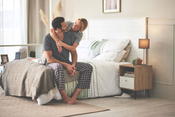 A couple hugging in bed at home. A happy mature man and woman in love, relaxing in the bedroom during the morning and embracing stock photo