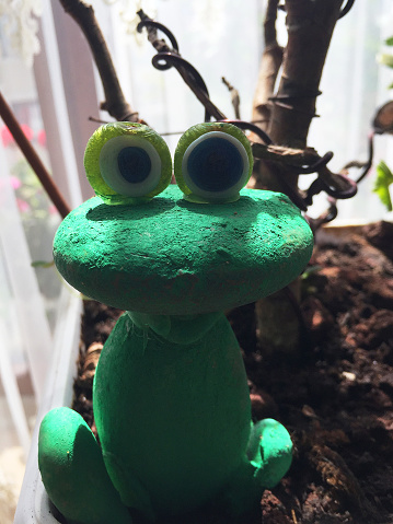 Frog decoration of an abandoned flowerbed in the winter