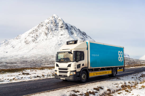 Co-op lorry journey in Scottish winter Glencoe, Scotland - A co-op lorry passing Buachaille Etive Mor in the Scottish Highlands during cold winter weather. buachaille etive mor photos stock pictures, royalty-free photos & images