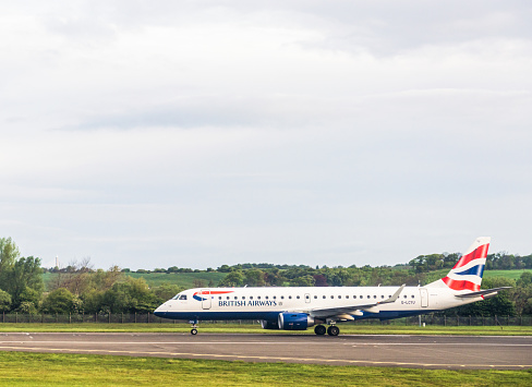 Edinburgh, Scotland - Side view of a British Airways Embraer E190SR jet about to take off on the runway at Edinburgh Airport.