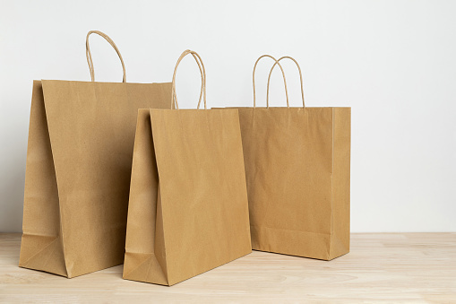 three brown paper bag on wooden table for mockup blank template