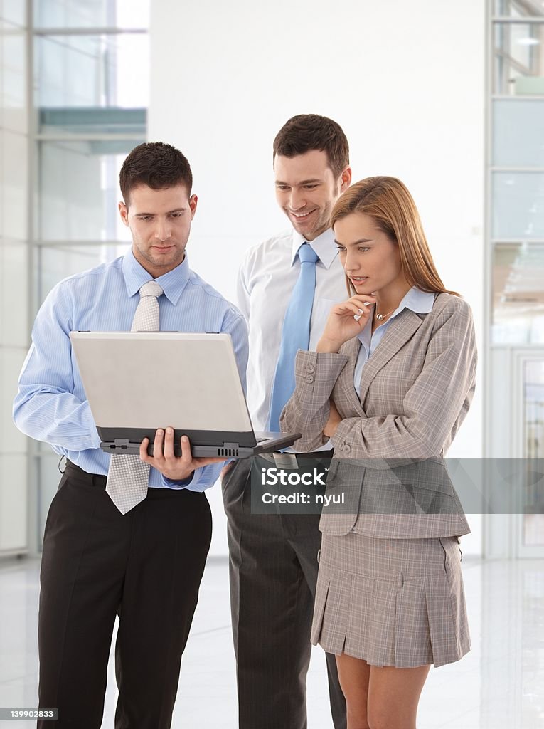 Giovani uomini d'affari guardando portatile schermo - Foto stock royalty-free di Rilassamento