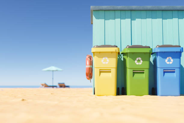 Recycling bins on sandy beach stock photo