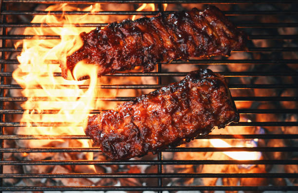 Barbecue meat is fried on a metal grate.