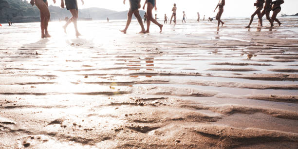 people walking on the beach at sunset in Plentzia village in Bilbao