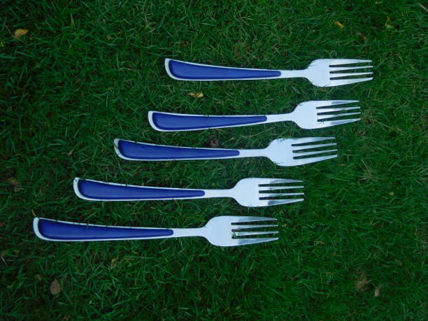 istock Forks on grass. Five metallic or stainless steel table forks placed in a line arrangement on green grass or lawn. 1399034462
