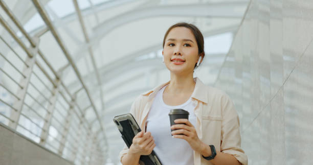 istock Asian businesswoman using Bluetooth headphones for conferences while commuting in transportation to work with happy smile. women use urban transport routes free internet technology in the city 1399036739