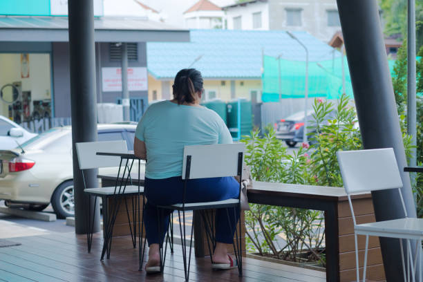 Smiling business woman in grey suit sits at outdoor cafe table on autumn day, waiting for order with relaxed confident mood, pleasant terrace atmosphere. Business lunch, lifestyle concept.