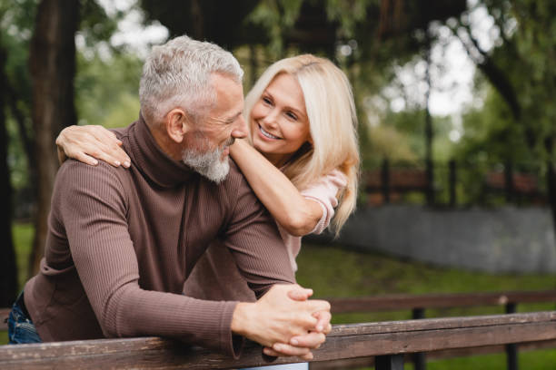 concept d’amour et de relation. couple hétérosexuel mature femme et mari conjoints s’embrassant ensemble tout en ayant un rendez-vous romantique dans le parc. - women love heterosexual couple color image photos et images de collection