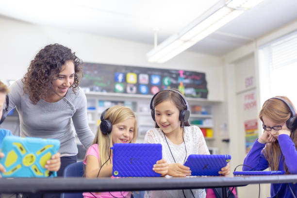 Elementary students using technology at school stock photo