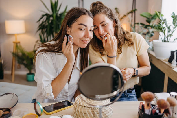 istock Two happy girls applying make up at home 1399046117