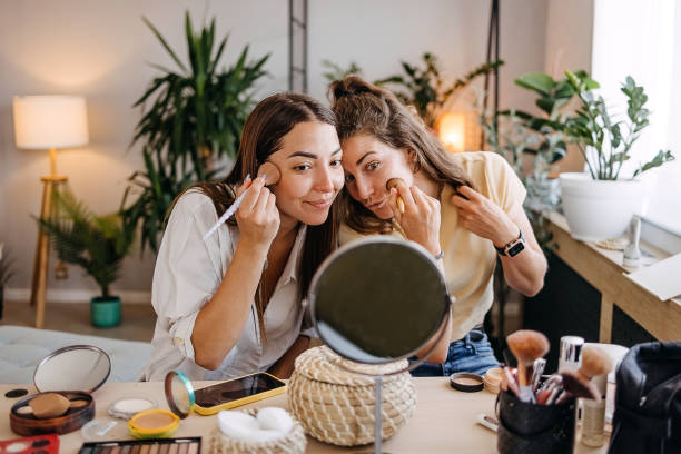 istock Two happy girls applying make up at home 1399046490