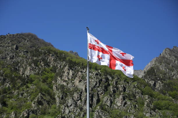 la bandera georgiana ondea en el viento en un día soleado - georgiano estilo fotografías e imágenes de stock
