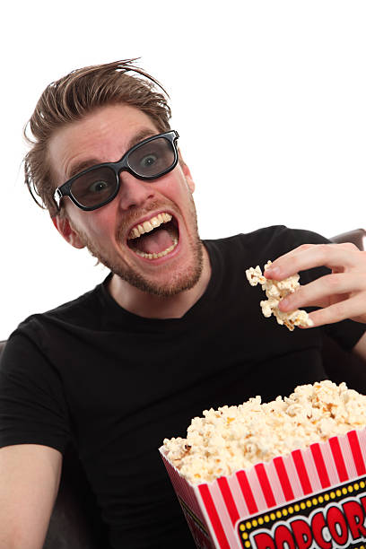 istock Happy man in 3-D glasses holding a popcorn bucket. 139904995