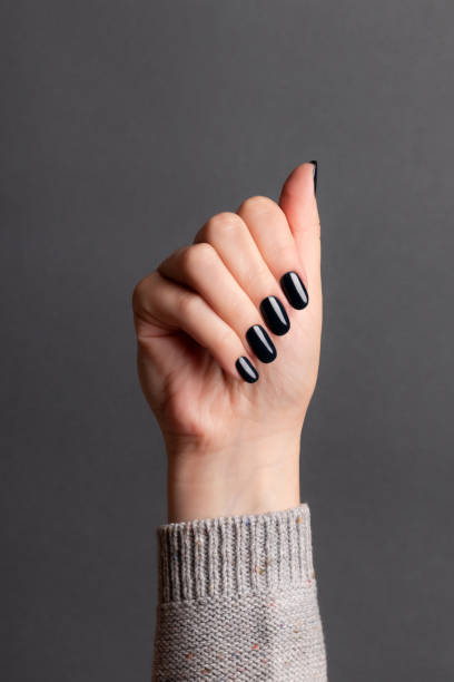 istock Female hand with black nails 1399050034
