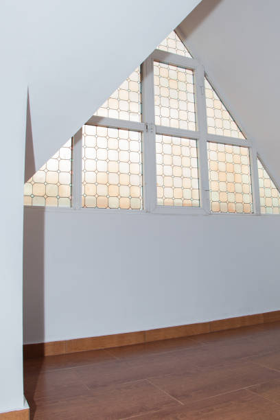istock Empty loft or attic, wooden floor, white walls and glass triangle window 1399051632