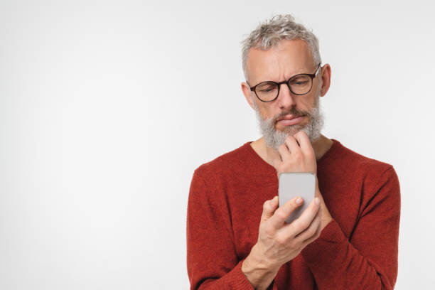 istock Pensive thoughtful caucasian mature middle-aged man using smart phone cellphone, thinking about buying new car, loan and cashback, social media isolated in white background 1399051937