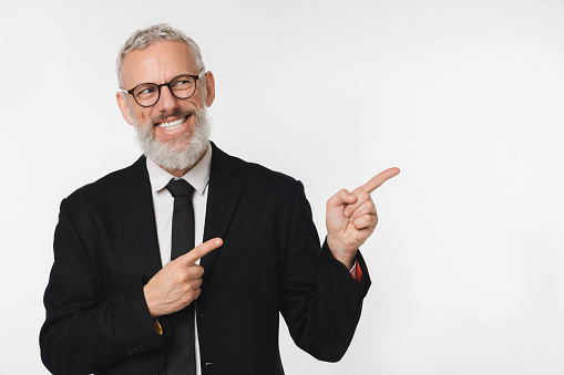 Successful caucasian mature middle-aged businessman ceo boss lawyer teacher freelancer pointing showing copy space free space isolated in white background