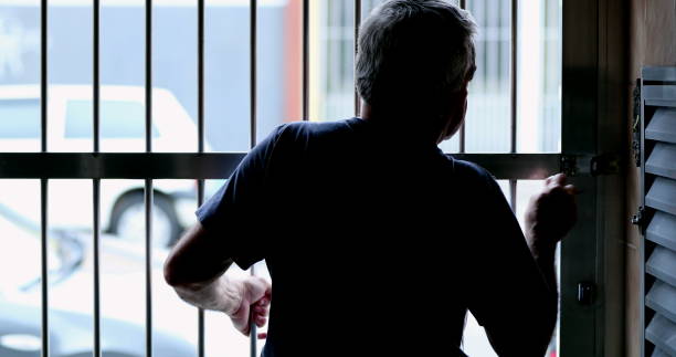 istock Man arriving home sliding metal gate and closing with lock 1399054596