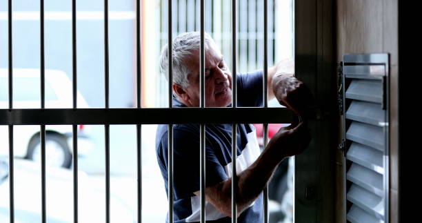 istock Man leaving home sliding metal entrance gate with lock for security 1399054618