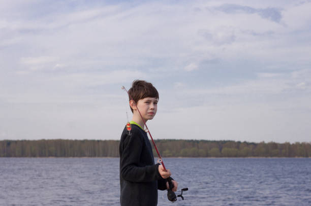 Portrait of a little boy fishing on the riverbank